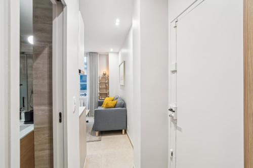 - un couloir blanc avec une chaise dans la chambre dans l'établissement Appartement Elegant 1BDR-2P - Paris Expo, à Paris