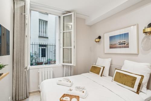 une chambre avec deux lits et une fenêtre dans l'établissement Appartement Elegant 1BDR-2P - Paris Expo, à Paris
