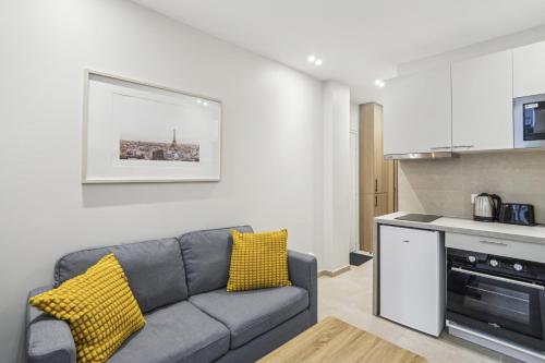 un salon avec un canapé et une cuisine dans l'établissement Appartement Elegant 1BDR-2P - Paris Expo, à Paris