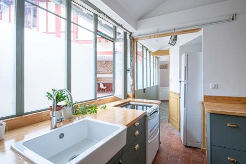 d'une cuisine avec un grand évier et des fenêtres. dans l'établissement Maison Historique - Château de Versailles, à La Celle-Saint-Cloud