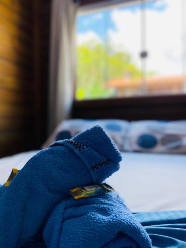 a blue towel sitting on top of a bed at Chalés do Parque Hospedagem in Penha