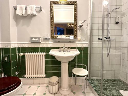 a bathroom with a sink and a shower at Hotel Der Kleine Prinz in Baden-Baden