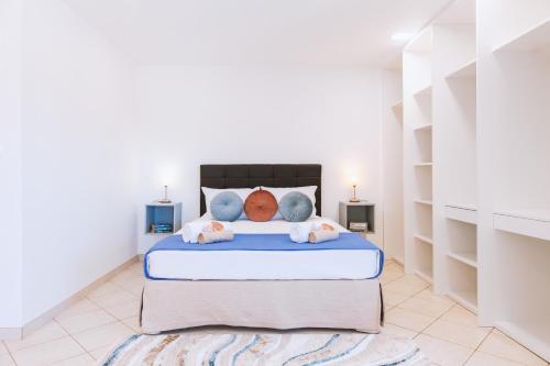 a bedroom with a bed with white walls and shelves at Villa Haven by Algarve Vacation in Lagoa