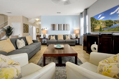 a living room with a couch and a table at Embrace Disney Magic at Our Luxe 6-BR Villa in ChampionsGate! in Davenport