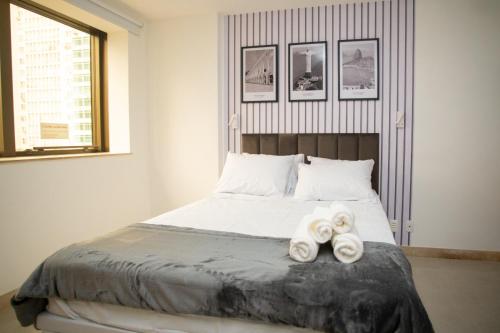 a bedroom with a bed with two towels on it at Flat Casa Mauá in Rio de Janeiro