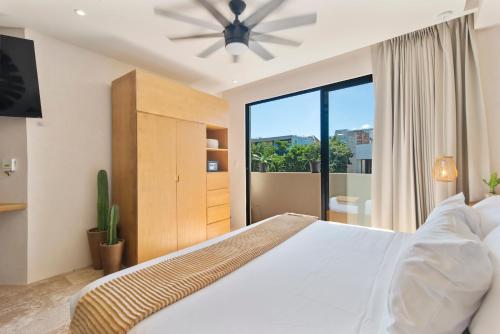 a bedroom with a large bed with a ceiling fan at A Sweet Jungle Suite in Aldea Zama in Tulum
