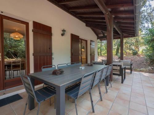 Une table à manger et des chaises sont disponibles sur la terrasse. dans l'établissement Villa Les Pins à deux pas de la plage PYLA SUR MER, à La Teste-de-Buch