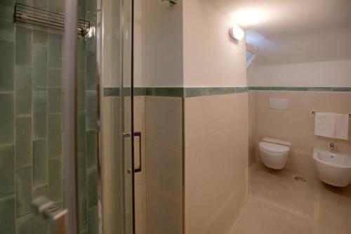 a bathroom with a toilet and a glass shower at Villa Pino in Furore