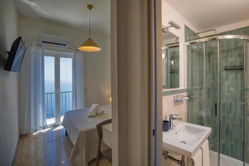a bathroom with a bed and a shower and a sink at Villa Pino in Furore