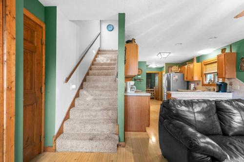 a staircase in a living room with a couch at Walk to Lake Lampe Cabin with Fireplace and Deck! in Lampe
