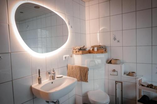 een badkamer met een wastafel en een spiegel en een toilet bij Bibo City Apartment in Bielefeld