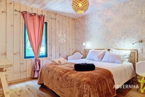 a bedroom with a large bed with a red blanket at La Montagne in Chambon-sur-Lac