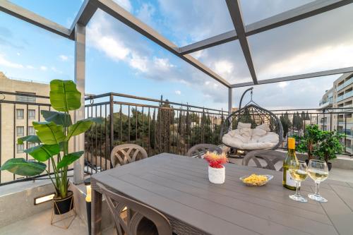 a patio with a table and glasses of wine at The David Story Boutique in Jerusalem