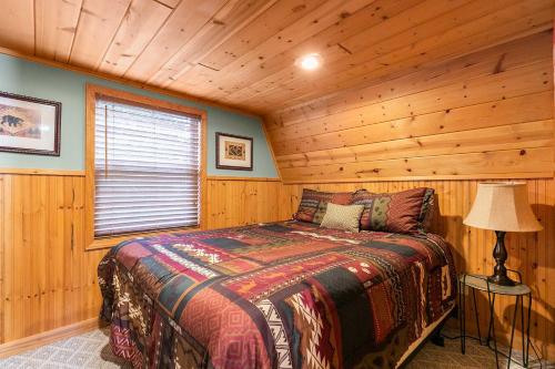 Lampeにある8 Mi to Dogwood Canyon Cozy Cabin with Deckの丸太小屋のベッドのある寝室
