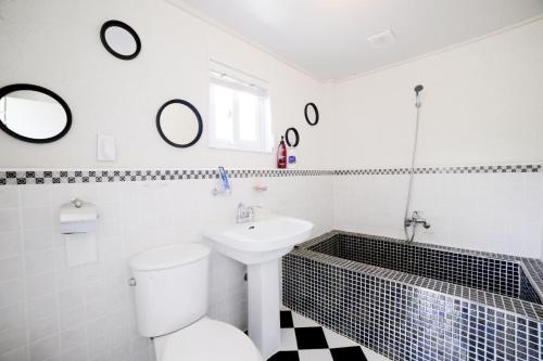 a bathroom with a toilet and a sink and mirrors at Walking Sky Pension in Gapyeong