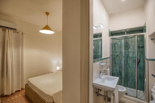 a bathroom with a bed and a sink and a shower at Villa Pino in Furore
