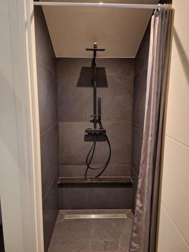 a bathroom with a shower with a light on the wall at Het Uitzicht in Malden