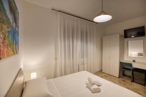 a bedroom with a white bed and a desk at Villa Pino in Furore