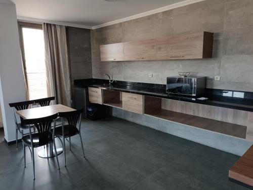 a kitchen with a counter and a table and chairs at HOTEL Dar Al Oumda in Nador