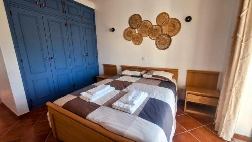Un dormitorio con una cama con armarios azules. en Apartamento Olhos do Mar, en Olhos de Água