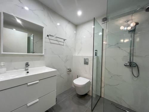 a bathroom with a shower and a toilet and a sink at Villa Símera in Laganas