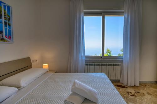 a bedroom with a bed and a large window at Villa Pino in Furore