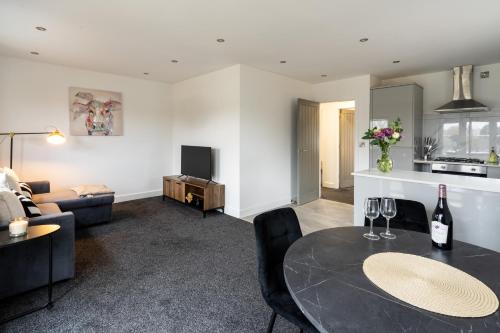 a living room with a table with wine glasses on it at Modern 2-Bed Apartment with Balcony, Close To Oxford City Centre With Free Parking in Oxford