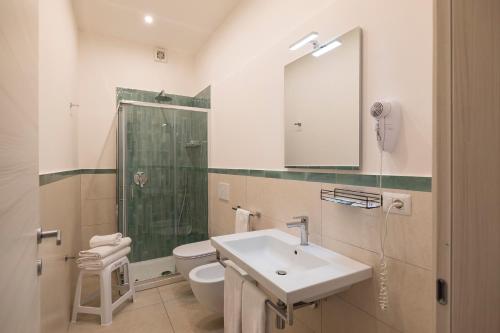 a bathroom with a sink and a toilet and a mirror at Villa Pino in Furore