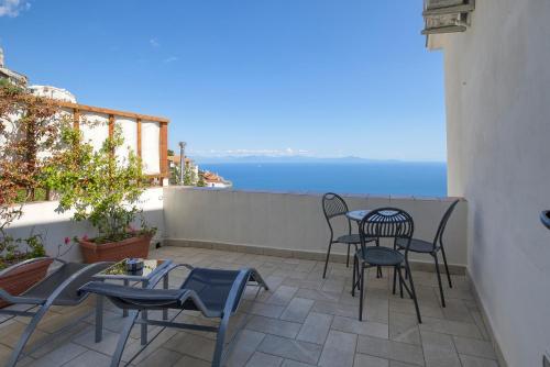 a patio with chairs and tables and a view of the ocean at Villa Pino in Furore