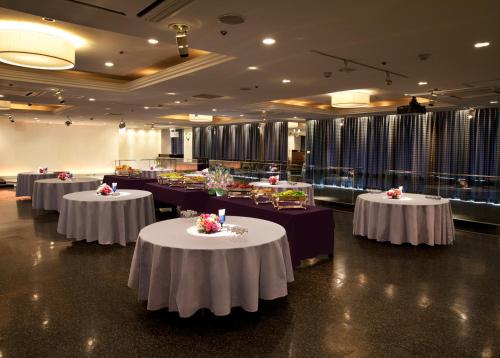 a banquet hall with tables with white table cloths at Koriyama View Hotel in Koriyama