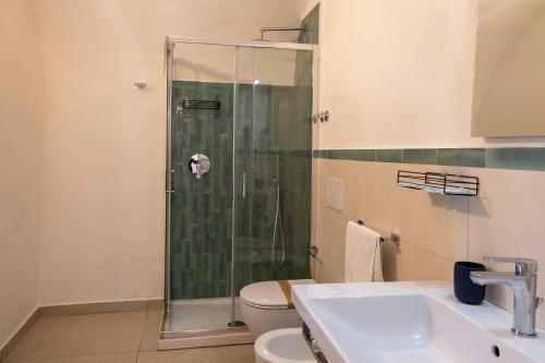 a bathroom with a shower and a toilet and a sink at Villa Pino in Furore