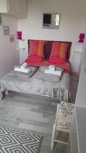 une chambre avec un lit avec des oreillers rouges dans l'établissement Un Havre de Paix aux Sanguinaires, à Ajaccio