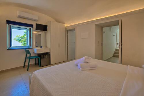 a bedroom with a white bed and a bathroom at Villa Pino in Furore