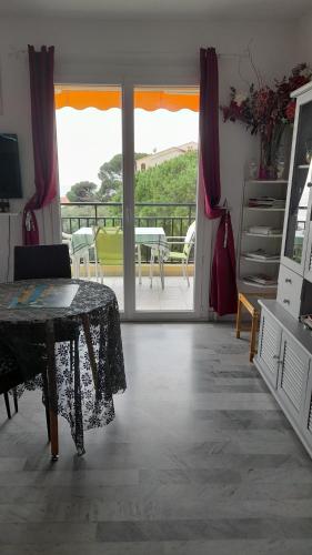 d'un salon avec une table et un balcon. dans l'établissement Un Havre de Paix aux Sanguinaires, à Ajaccio