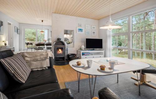 a living room with a table and a fireplace at Fyrrebakken in Spidsegård