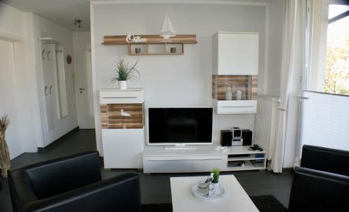 a living room with a flat screen tv on a stand at Leuchtturm 7 in Grossenbrode