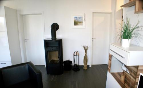 a living room with a black stove in a room at Leuchtturm 7 in Grossenbrode