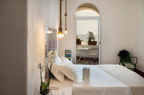 a bedroom with a bed and a table with flowers at Casa al Sole Boutique Hotel in Ischia