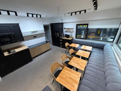 a room with a couch and tables and a tv at JADE - guesthouse in Buzau