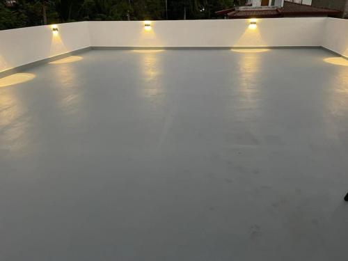 a white concrete patio with lights on it at Champ Villa in Kamburugamuwa