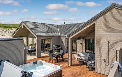 ein Whirlpool auf der Terrasse eines Hauses in der Unterkunft Amazing Home In Hvide Sande With Sauna in Bjerregård