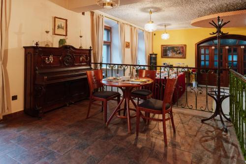 a dining room with a table and chairs and a piano at Penzion Bene in Chotěboř
