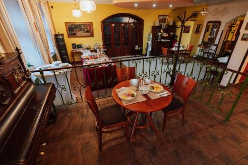 a table and chairs in a room with a balcony at Penzion Bene in Chotěboř