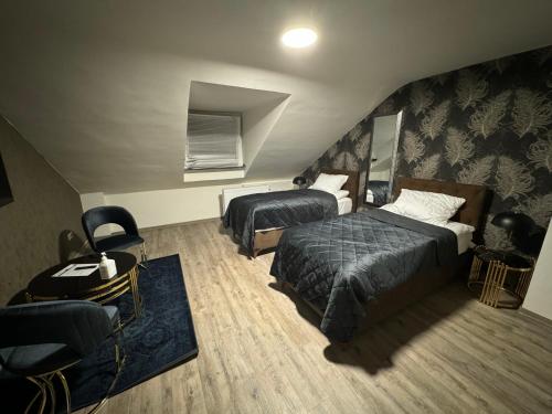 a hotel room with two beds and a chair at Haus Thomas in Dortmund