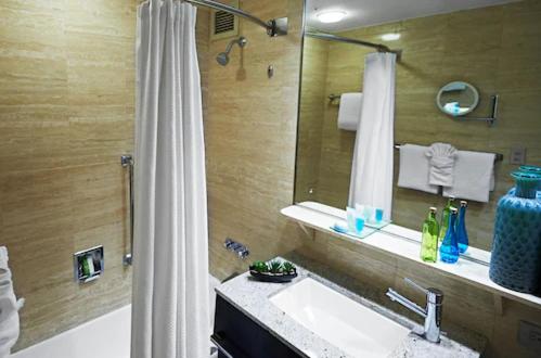 a bathroom with a tub and a sink and a shower at Miami International Airport Hotel in Miami