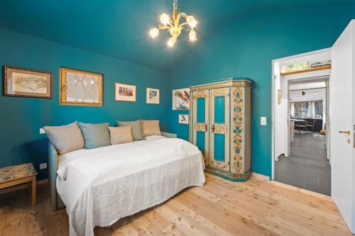 a bedroom with a bed and a blue wall at Chesa Alvan - Surlej in Surlej