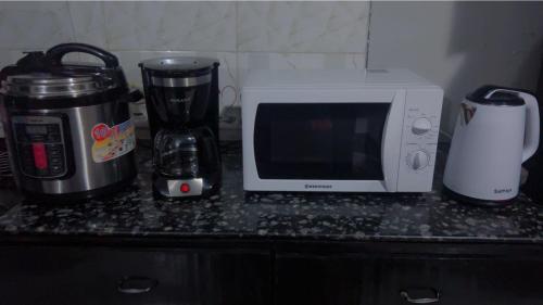 a kitchen counter with a microwave and a coffee maker at Otoria Apartments Home away from Home in Dar es Salaam