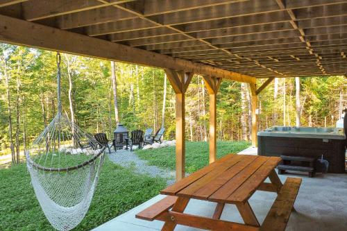 a hammock on a screened in porch with a grill at Chalet Le Silverson in Brownsburg