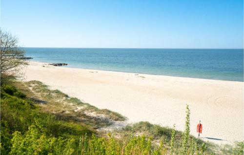 a person standing on a sandy beach next to the ocean at Holiday Home Lersøvej in Rønne