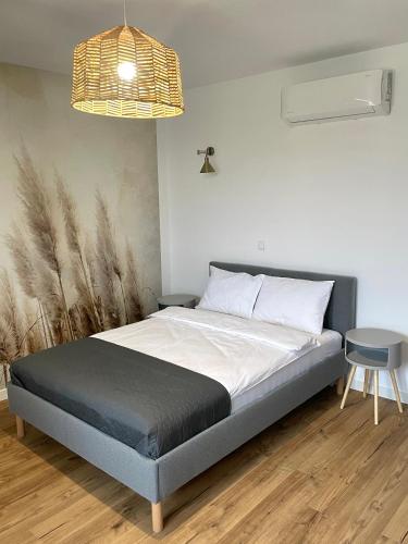 a bed in a bedroom with a lamp and a table at MAGURSKA PANORAMA l samodzielne zameldowanie l self check-in in Chrząstówka
